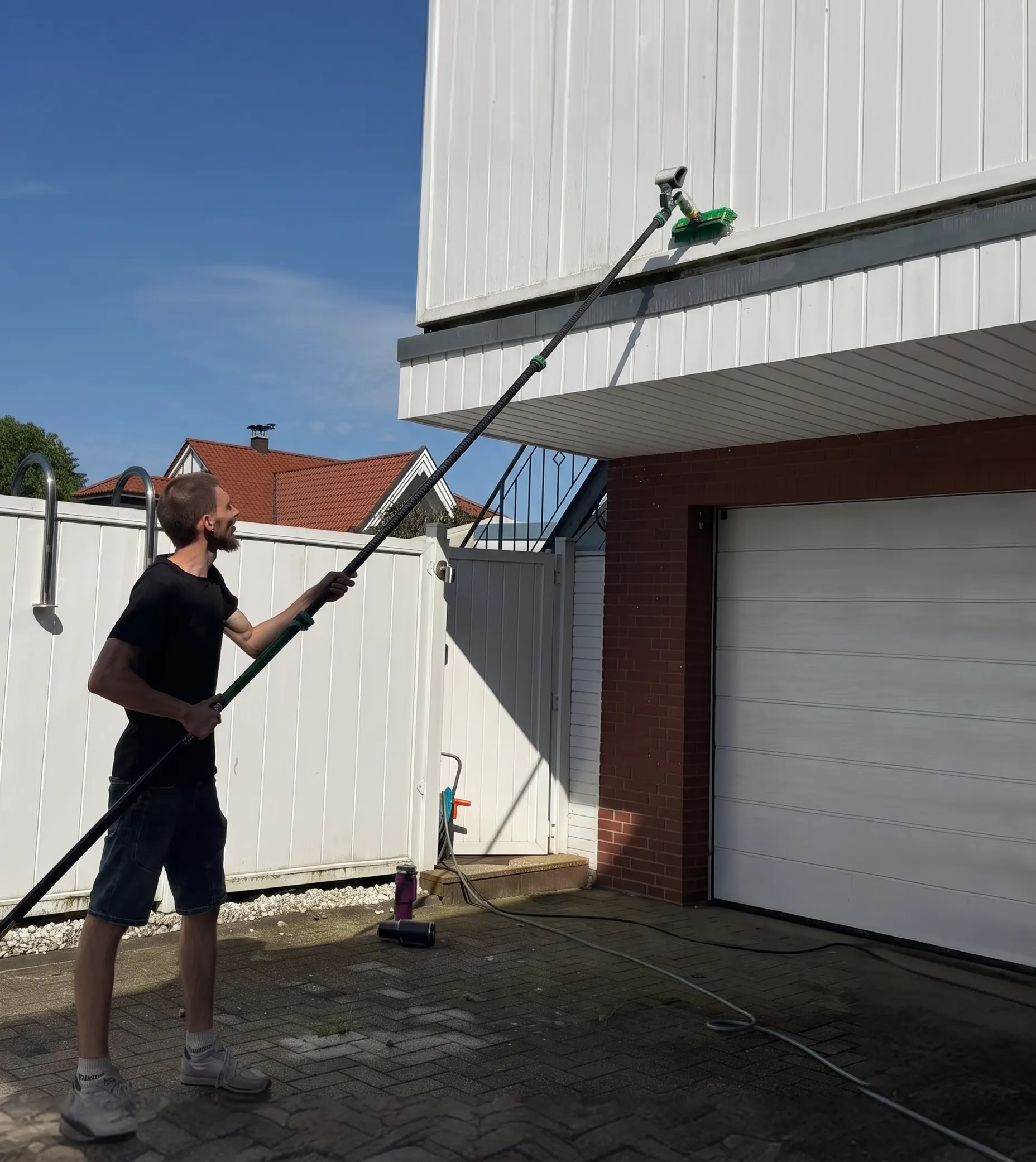 Fensterputzer aus Oldenburg reinigt eine Fassade mit der Teleskopstange