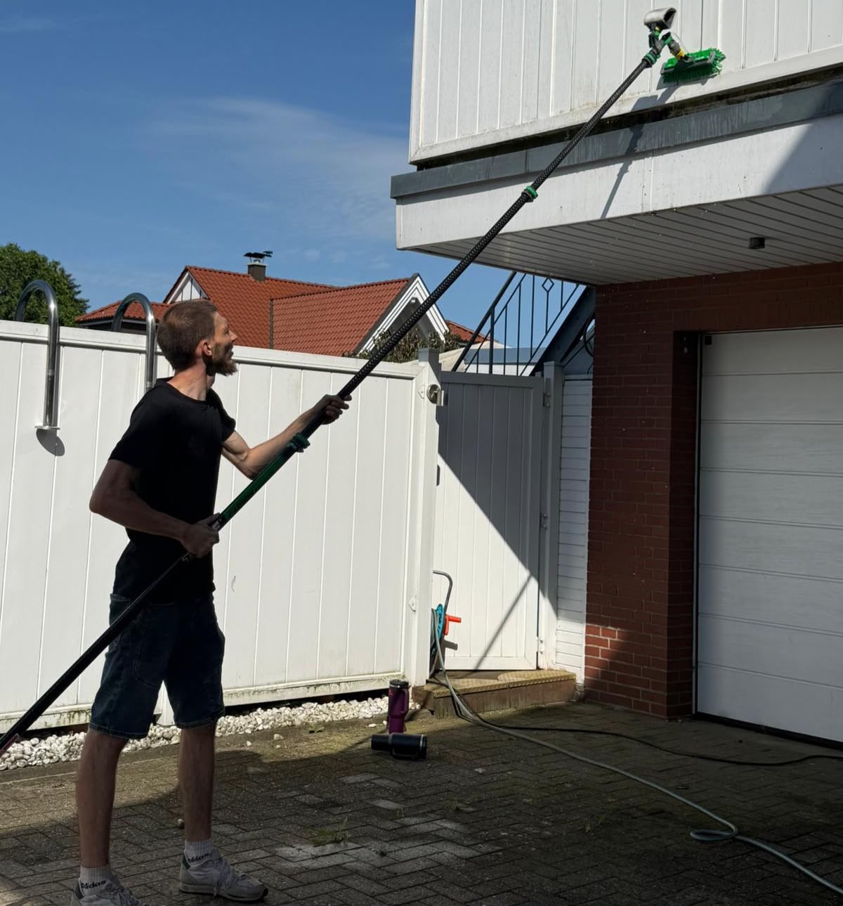 Fensterputzer aus Oldenburg reinigt eine Fassade mit der Teleskopstange